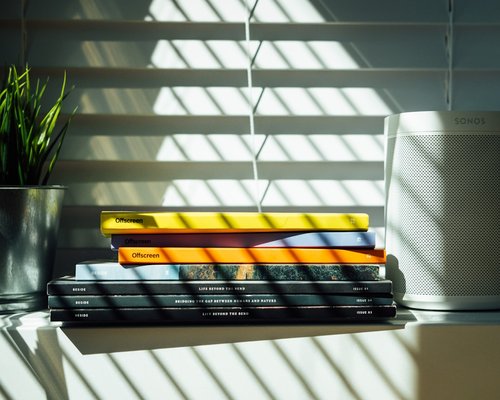 A book by a sunny window with soft white curtains